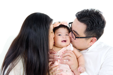 asian parent kissing their baby girlの写真素材