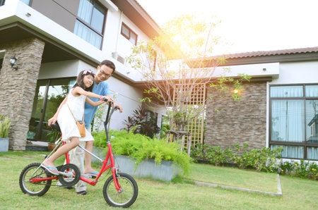 Healthy father and daughter playing together outside their new house. Home fun  lifestyle, family concept.の写真素材