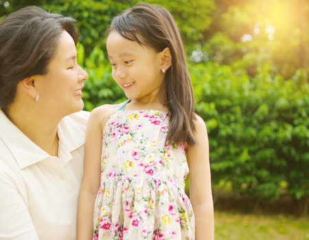 Outdoor portrait of asian mother and her lovely daughterの写真素材