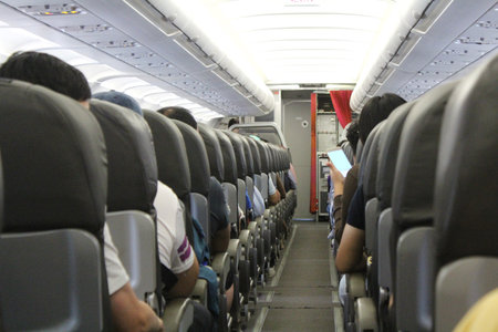 Interior of airplane with passengers on seats waiting to take off.の写真素材