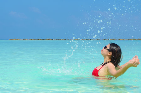 Woman swim and relax in the crystal-blue sea of tropical beach at  Maldives islands. Happy lifestyle concept.の写真素材