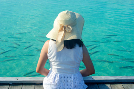 Beautiful asian woman in sunhat sitting and  relaxed at tropical beach in Maldivesの写真素材