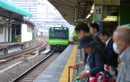 TOKYO, JAPAN - May 31, 2018. Commuters waiting for the train at Yatsuyai Railway Station platform.のeditorial素材