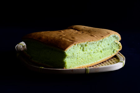Pandanus   sponge cake  on wooden basket isolated on black backgroundの写真素材