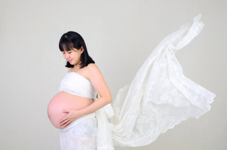 Asian pregnant woman holding her bellyの写真素材