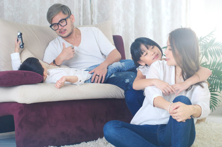 Asian family enjoying family life at living roomの写真素材