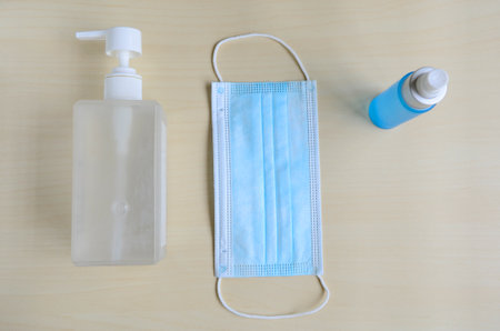 Medical face mask with alcohol sanitizer gel on wooden background for covid-19 Coronavirus prevention concept.の写真素材