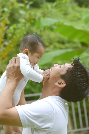 Happy father's day! joyful young dad  hugging his cute son at outdoor park.の写真素材