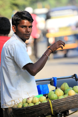 Pune, India - October 22, 2011 Unidentified Indian man sells guava beside street in Pune city のeditorial素材