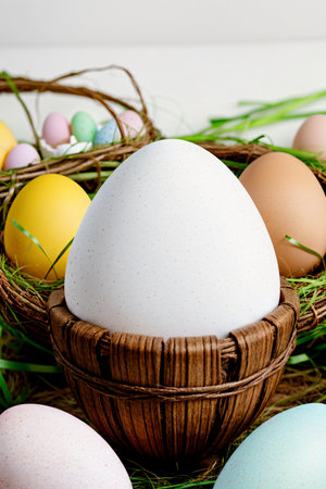 Easter eggs in the basket with green grass on a white backgroundの素材