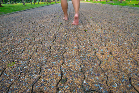 The man was walking on the road barefoot in the park.の写真素材