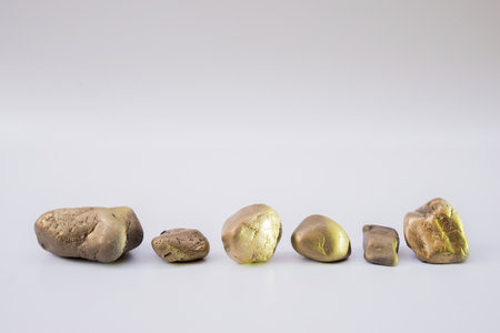 Balance the concept of placing different gold stones together on a white background with space.