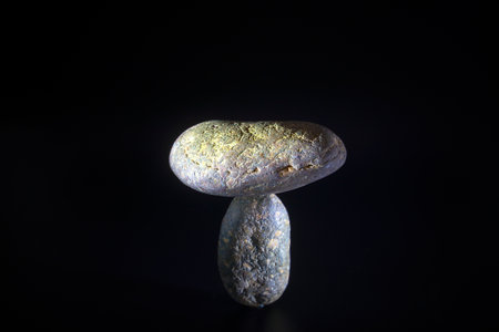 Balance concept, natural texture stones are nestled together in balance on a black background.の写真素材