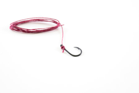 Fishing hook with a red rope on a white background.の写真素材