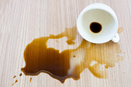 Spilled coffee cup stain on wooden floorの写真素材
