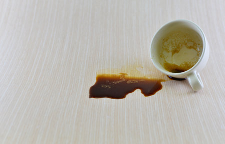 Spilled coffee cup stain on wooden floorの写真素材
