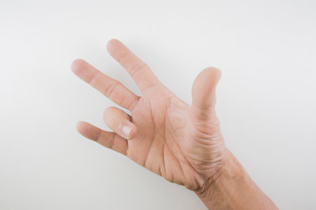Finger of seniors who have problems trigger fingers on a white background.の写真素材