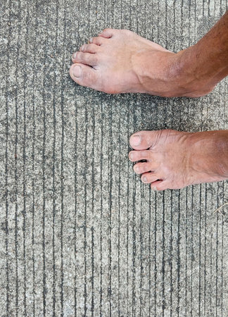 Picture of bare feet on an old concrete floorの写真素材