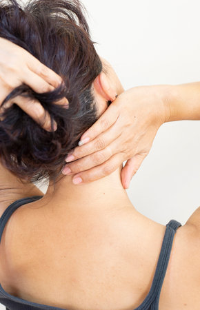 Postures showing pain and fatigue in the neck, back, and shoulder muscles of womenの写真素材