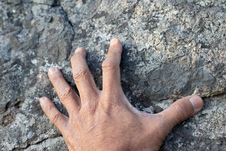 The old man hand was grasping on the rocky surface.の写真素材