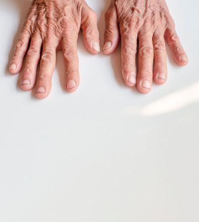Old man's wrinkled hands on white groundsの写真素材