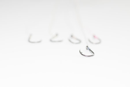 A sharp-edged hook lands against the underside hook that blurry on a white floor with empty space.