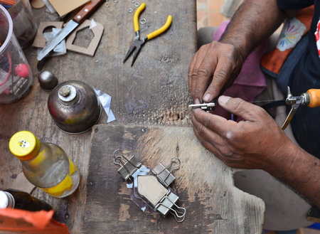Rough and dirty hands are working on many tools placed on the table.の写真素材