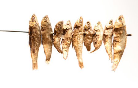 The food is grilled fish on a white background.