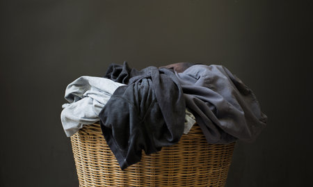 Stack clothes in a basket with a gray background.