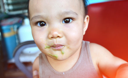 Face and gesture expression of Asian babies during eating time.