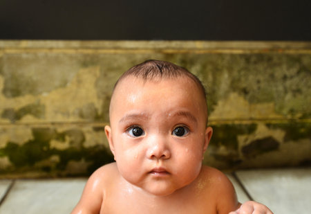 Portrait child's face wet from the water and a lovely gesture.の写真素材