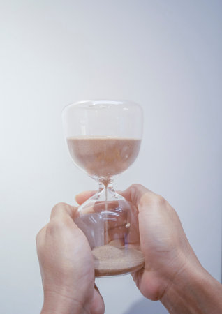 Person's hand holding an hourglass