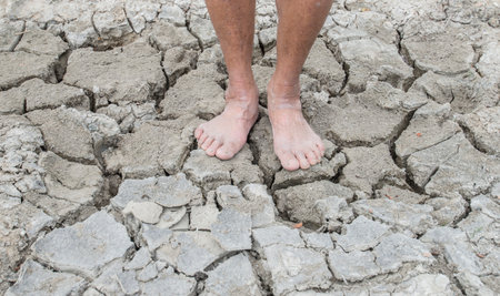 barefoot standing on the cracked groundの写真素材