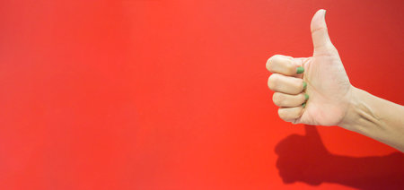 Conceptual image and idea, human hand and finger gesture symbol on bright red background on empty space.の写真素材