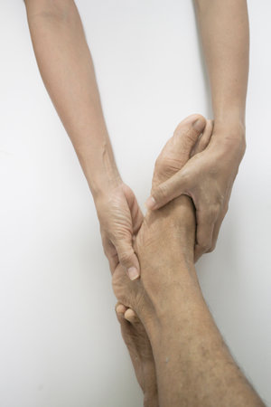 The hand pulling the elder's leg represents muscle massaging and stretching.の写真素材