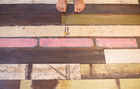Bare feet man standing on surface pattern, old wooden floor, pastel tones.の写真素材