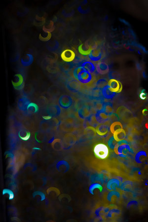 Brightly colored spheres of light sparkle against a dark black background.の写真素材