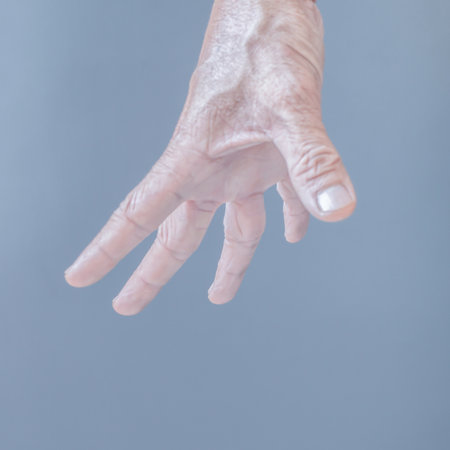 The gesture of rough hands and wrinkles of the elderly on a gray background.の写真素材