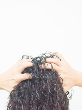 Hand holding her own curly hairの写真素材