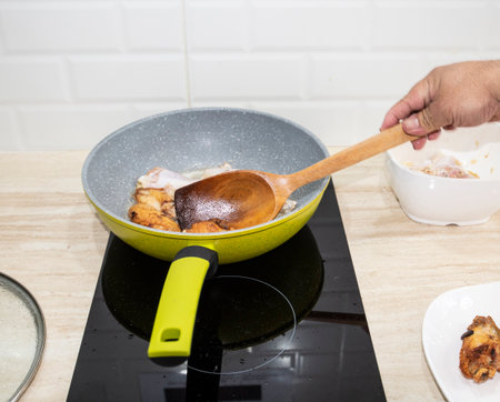 Image of food being fried on an electric stoveの写真素材