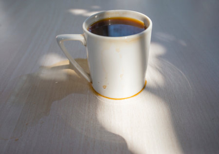 Spilled coffee cup stain on wooden floorの写真素材