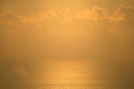 The sky and water surface with golden sunlight sparkling.