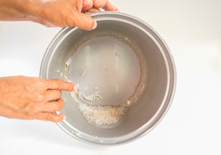 Old rice in a rice cooker on a white background