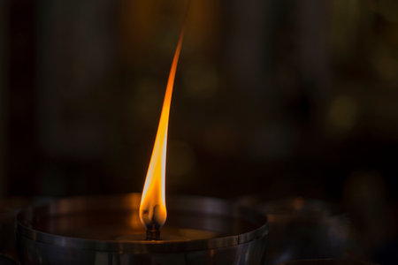 Burning candle in the church. Shallow depth of field.の写真素材