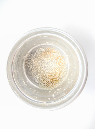 Grains of rice in a bowl on a white background.の写真素材