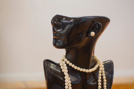 Vintage black female figurine with pearls and pearl necklace.の写真素材