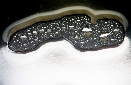 Water drops on a glass surface with a black background, macro photography