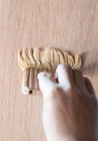 hand holding paint brush on a wooden background, top view with copy spaceの写真素材