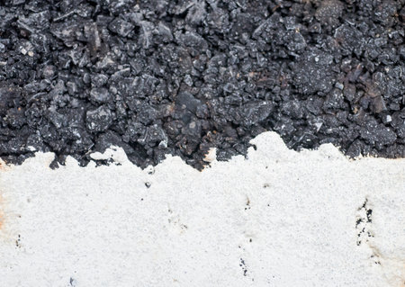 Close-up of a wall with white paint and black coal.