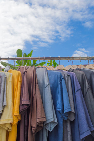 Clothes hanging on a clothesline against blue sky with white cloudsの写真素材
